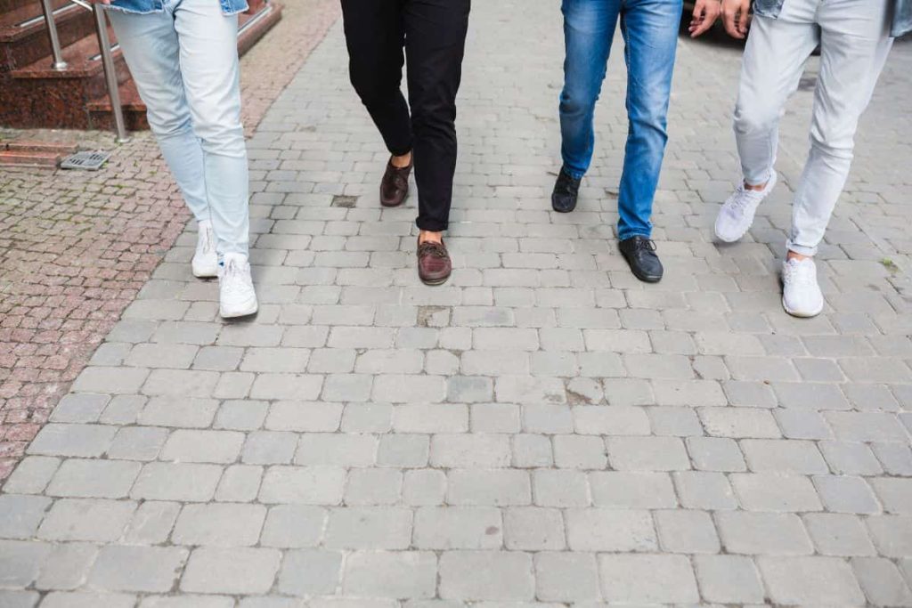 orang yang berjalan di atas paving block 